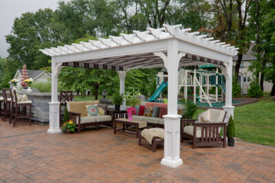 white vinyl pergola over an outdoor sitting area
