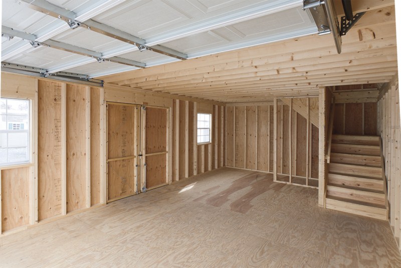 interior of two-story garage with double doors and a staircase