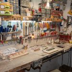shed workshop with various tools hanging on the wall and a workbench