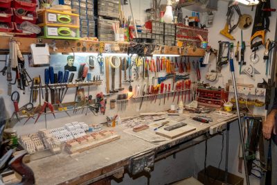 shed workshop with various tools hanging on the wall and a workbench