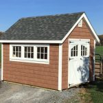 classic garden cottage shed with brown siding and white doors and windows