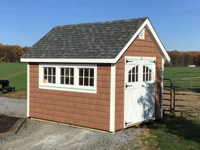 classic garden cottage shed with brown siding and white doors and windows