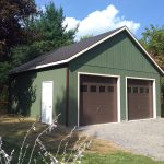 doublewide 2 story garage with green siding and brown garage doors